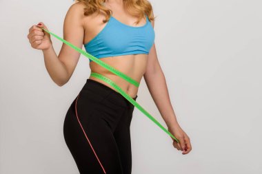 Genç, güzel bir kız, zayıf vücudunu ölçüyor.