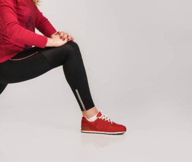 Genç, esnek bir kadının gri arka planda aşırı bölünme yapması.