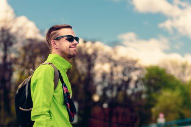 Sırt çantasıyla gezen yakışıklı bir gencin portresi.