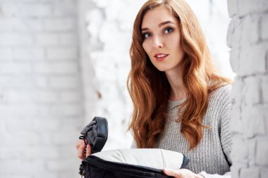 Güzel kadın fotoğrafçı fotoğraf çekimi için ekipmanları çıkarıyor.