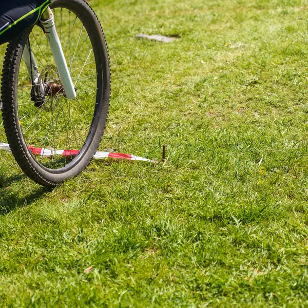 Erkek bisikletçinin yeşil çimlerin üzerine su koyduğu yakın plan.