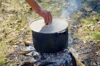 Ormanda piknikte yanan çorbayı pişiren kişiye yakın çekim