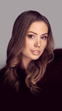 Stüdyoda poz veren zarif kürklü güzel esmer kadın model.