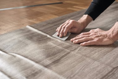 Marangozların elleri birbirine yapışkan filmden havayı temizliyor.