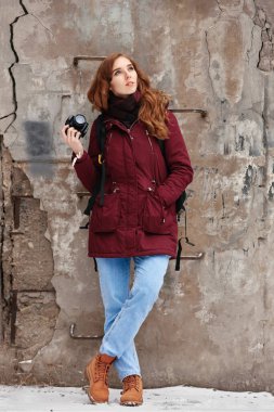 Açık hava fotoğraf çekiminde fotoğraf makinesi olan kızıl saçlı genç bir kadın.