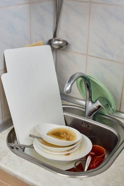 Mutfak lavabosunda bir yığın kirli bulaşık var.