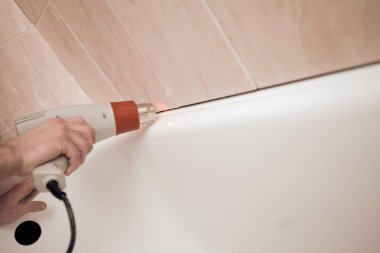 Erkekler tuvaletteki boşlukları özel bir aletle kurutuyor.