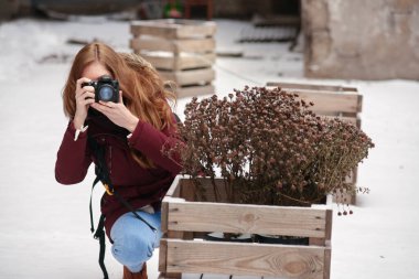 Genç bayan fotoğrafçı açık havada fotoğraf çekimi yapıyor.