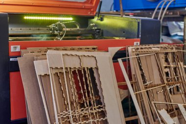 Programlanabilir lazer makinesi ve yanında duran kontrplak şablonları