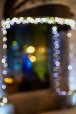 Parlak elektrik çelengi ile süslenmiş pencerenin bulanık fotoğrafı