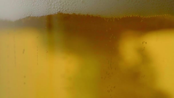 ボトル詳細ショットマクロスーパースローモーションビデオからガラスに泡で冷たいクラフトライトビールを注ぐ — ストック動画