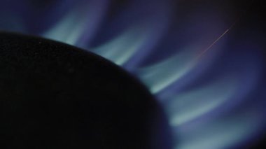 Metal ocağın üzerindeki gaz alevinin sinematik makro görüntüsü. Gaz ocağının mavi alevlerle tutuşan makro görüntüsü. Gaz sobasının titreşen alevinin detaylı makro görüntüleri. Mutfak gaz sobasının yakın çekimi ısı dalgalarıyla tutuşuyor.