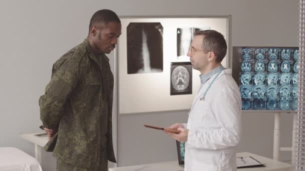 Medium Slowmo Serious African American Soldier Caucasian Male Radiologist Doctor — Vídeo de stock