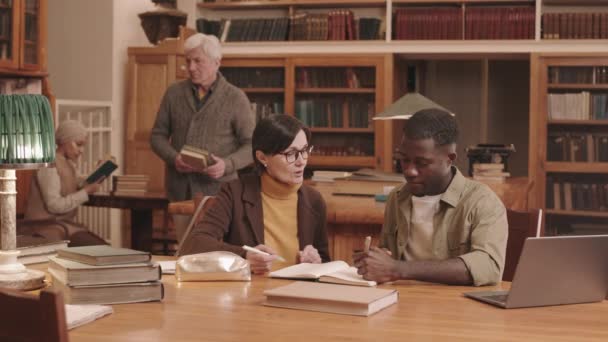 Mittlere Verlangsamung Der Afroamerikanischen Studentin Und Professorin Die Der Bibliothek — Stockvideo