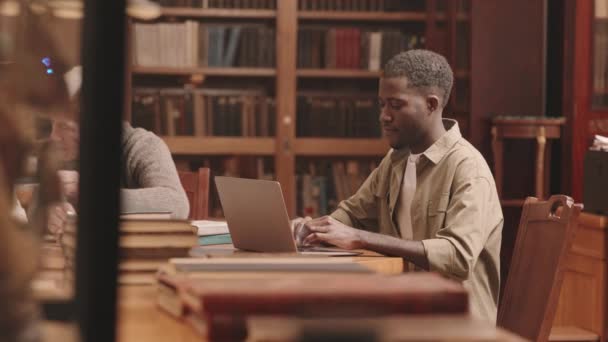 Medium Slowmo Afroamerikanska Manliga Student Studerar Laptop Sitter Vid Skrivbord — Stockvideo