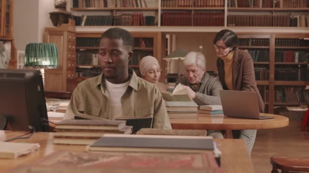 Medium Slowmo Diverse Young Adult People Reading Discussing Books Library — Vídeo de Stock