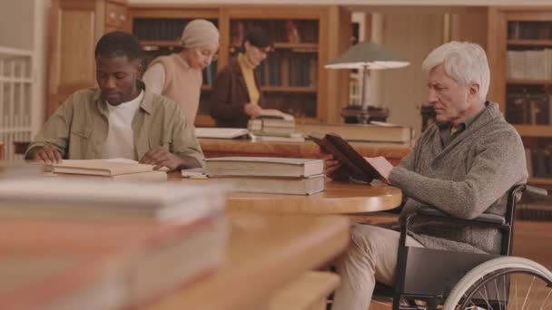 Medium Slowmo Senior Caucasian Man Disability Reading Book Sitting Wheelchair — Stok Video