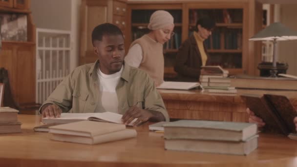 Medium Slowmo African American Male College Student Reading Study Materials — Stockvideo