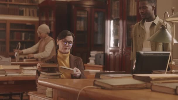 Medellångsam Mogen Kaukasisk Kvinna Glasögon Som Arbetar Ett Offentligt Bibliotek — Stockvideo