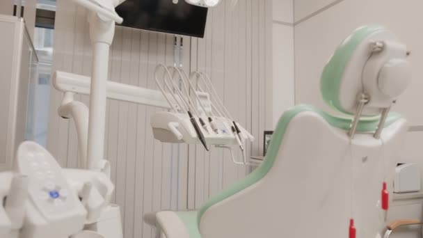 歯の椅子 ドリル 患者の歯が付いている現代の歯医者のオフィスの内部の誰も減速しないコンピュータモニタ上のXray — ストック動画