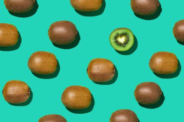 Çapraz mavi arka plan, sağlıklı beslenme ve vegan konsepti üzerine köşegen çizgileriyle taze kivi meyvelerinin grafiksel üst görünüm deseni, kopyalama alanı