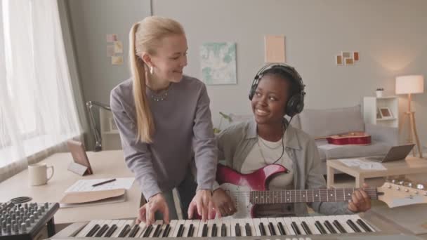 Medium Slowmo Energetic Diverse Female Duo Playing Keyboard Electric Guitar — Stock Video