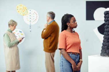 Çağdaş sanat eserleri sergisini ziyaret eden üç kişilik bir grup.