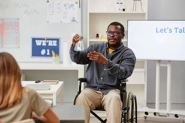 Portret Afroamerykańskiego Nauczyciela Wózku Inwalidzkim Trzymającego Szklaną Zlewkę Podczas Lekcji — Zdjęcie stockowe