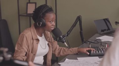 Rock müzik grubunda mikrofonla şarkı söyleyen ve ev stüdyosunda yeni şarkı kaydeden enerjik Afrikalı Amerikalı genç bir kadının orta yavaşlığı.