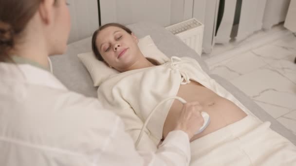 Медленно Через Плечо Молодой Счастливой Белой Женщины Лежащей Медицинском Диване — стоковое видео