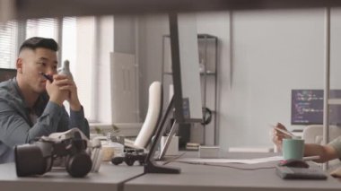 PAN yavaş ilerleyen çeşitli geliştiriciler meslektaşlarının kendi yarattığı video oyununu sunuşunu izliyorlar, modern bilişim ofisindeki masada oturuyorlar.