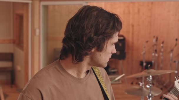 일렉트릭 기타를 연주하는 코카서스 남성의 느림보 스튜디오에서 밴드와 새로운 노래를 — 비디오