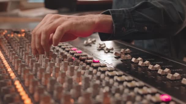 专业音乐录音室男性手操作音频混音控制台的特写镜头 — 图库视频影像