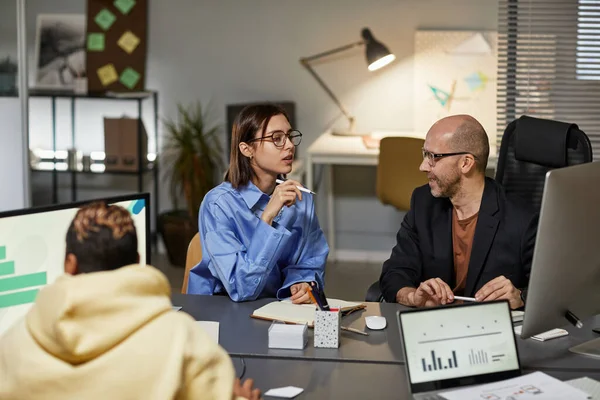 stock image Portrait of young businesswoman talking to male colleague during team meeting in office