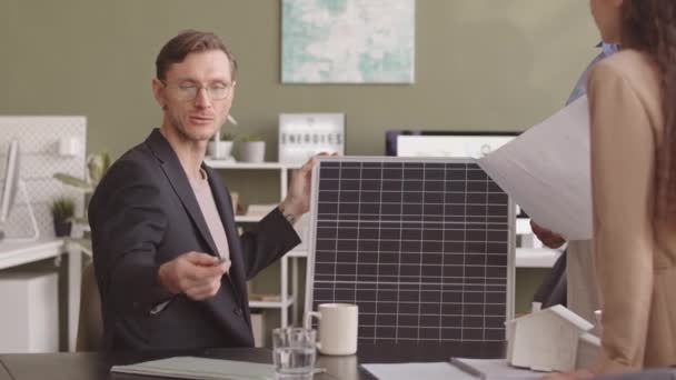 中等速度的年轻高加索工程师向在职替代能源项目的女性同事解释和介绍太阳能电池板 — 图库视频影像