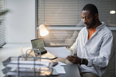 Beyaz ofis içinde çalışırken dizüstü bilgisayar kullanan yetişkin Afrikalı Amerikalı adamın portresi, boşluğu kopyala