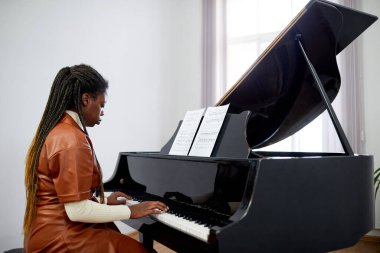Afrikalı bayan piyanist piyanoda piyano çalmaya odaklanmış, müzik okulunda okuyor.