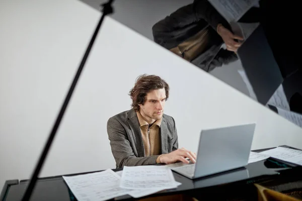 Estudante Sério Concentrando Seu Trabalho Laptop Enquanto Sentado Piano Cauda — Fotografia de Stock