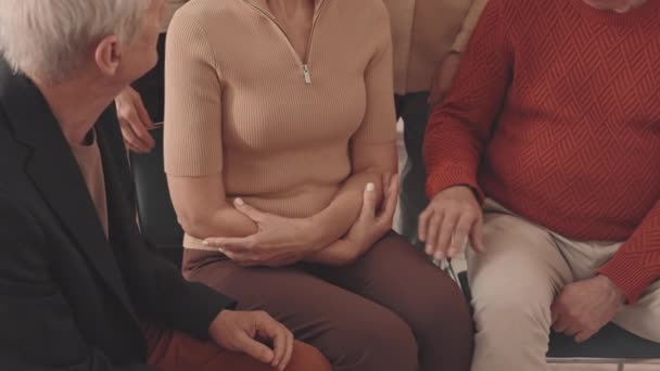 成熟したブロンド白人女性の中低速うつ病は彼女の問題を共有し 他のコミュニティメンバーは室内でサポートグループ会議中に彼女を慰めながら — ストック動画