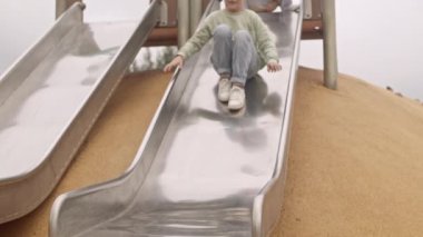 Dört neşeli çoklu etnik erkek ve kız çocuk parkında kayıyor, yazları dışarıda birlikte geçiriyorlar.