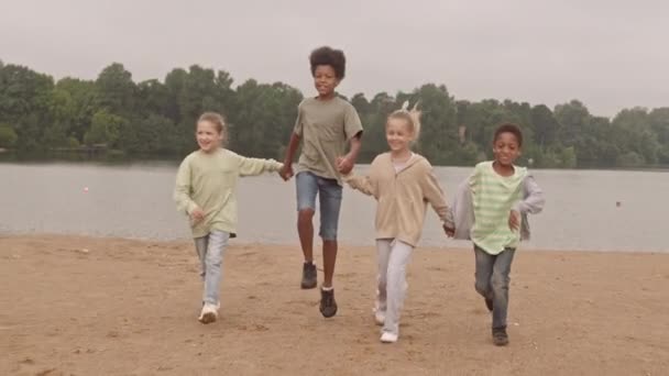 Slowmo Four Joyful Multiracial Kids Holding Hands Running Jumping Camera — Stock Video