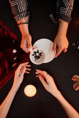 Kadın falcıya tepeden bakınca kahve falı bakarken genç bir kadınla ruh çağırma seansında kaderi anlatıyor.