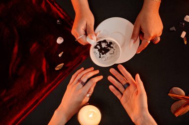 Top down view at female fortune teller reading coffee telling destiny in seance with young woman, copy space clipart