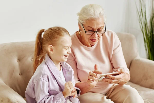 Minimaalinen Muotokuva Vanhempi Isoäiti Käyttää Älypuhelinta Pieni Tyttö Hymyilee Onnellisesti — kuvapankkivalokuva
