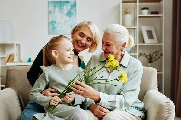 Portrait Smiling Little Girl Giving Flowers Grandmother Mothers Day Cozy — Stock Photo, Image