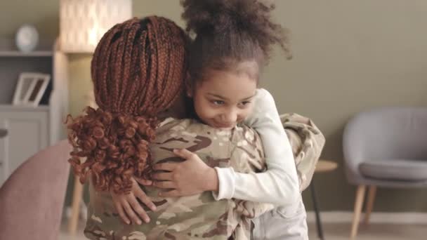 身着军服的美国黑人女兵在休完军假回家后抱着她的小女儿 — 图库视频影像