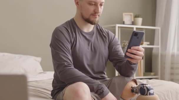 Slowmo Vousatý Mladý Muž Protézou Nohu Rolování Smartphone Zatímco Sedí — Stock video