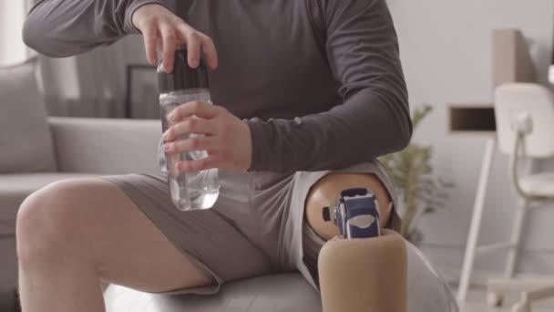 Tilt Slowmo Des Jungen Kaukasischen Mannes Mit Beinprothese Wasser Trinken — Stockvideo