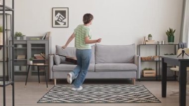 Sosyal medyada yayınladığı için kendini dans ederken gösteren enerjik, beyaz bir kadının tam boy çekimi.