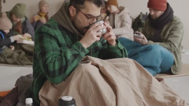 Slowmo Portret Brodatego Uchodźcy Okularach Patrzącego Kamerę Wypiciu Gorącej Herbaty — Wideo stockowe